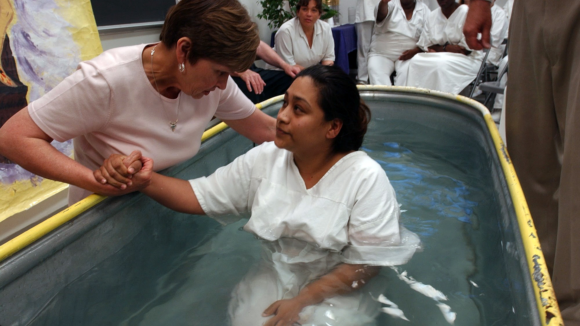 In a photograph from 2003, shortly after Linda and Dallas Strom moved to Texas, Linda baptizes an inmate at Woodman.