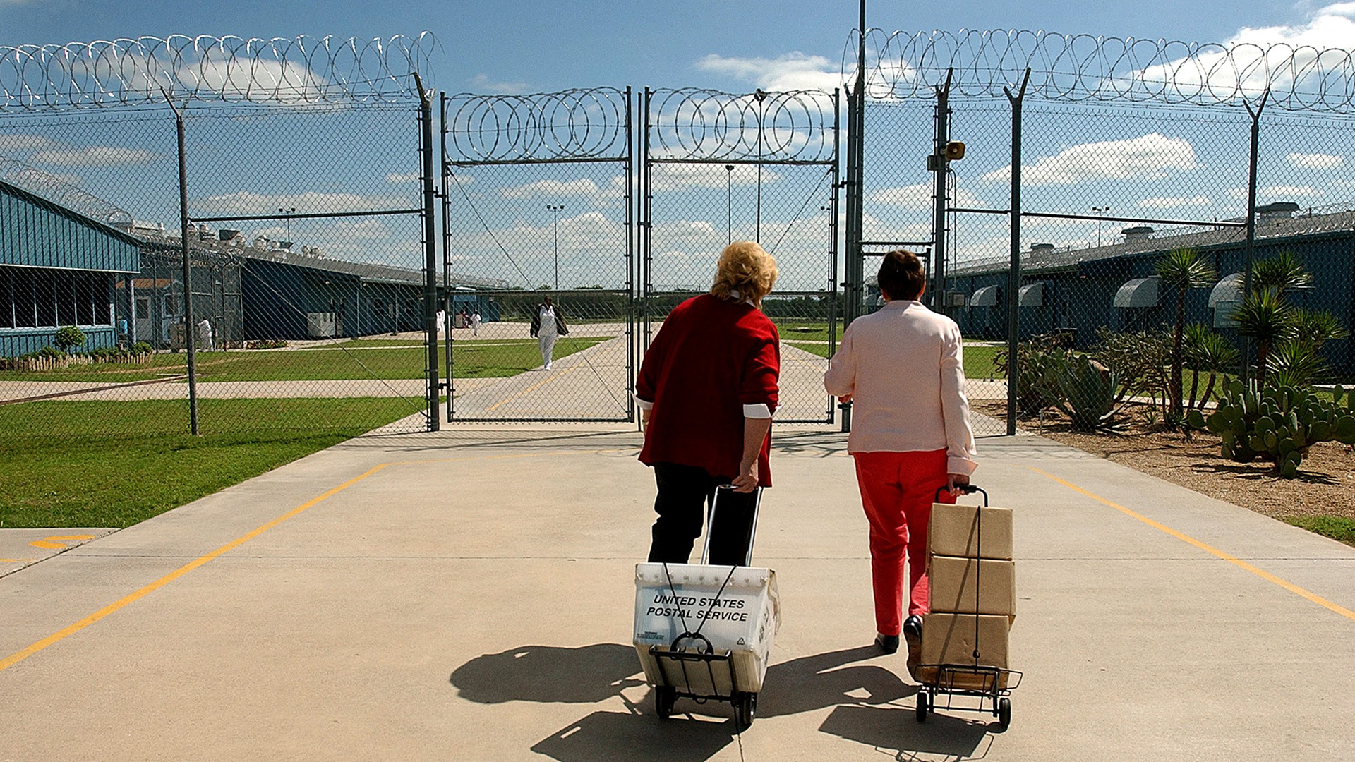 Linda and volunteer chaplain Carol Ross (at left) entering the Linda Woodman State Jail in Gatesville, carrying mail and boxes of Linda's book, <i>Karla Faye Tucker, Set Free: Life and Faith on Death Row.</i>