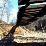 A photo of the aftermath of Hurricane Helene in Old Fort, NC shows railroad tracks suspended in midair. McDowell County flood relief efforts continue as the community rebounds from devastation.