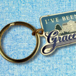 'I’ve Been to Graceland' keychain illustration accompanying Sybil Rosen’s short story 'Graceland,' part of her 'Riding the Dog' collection of Greyhound bus stories.