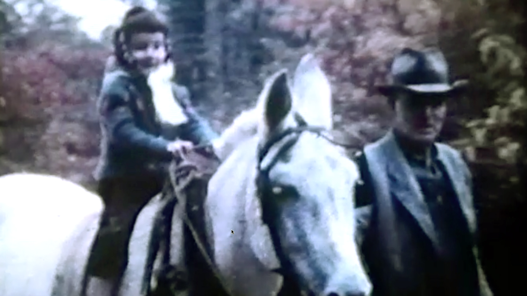 A child riding a white mule next to an older man in a wooded setting, symbolizing solastalgia, environmental grief, and childhood memories of rural Georgia.