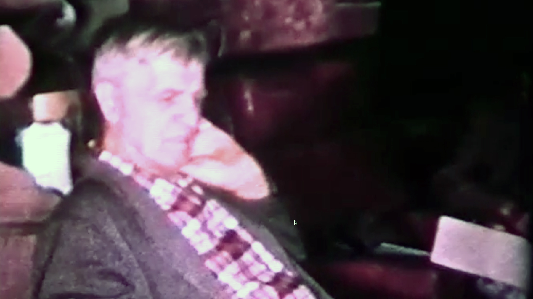 Tracy Thompson's grandfather, Kleck, seated indoors in a frame from an old home movie.